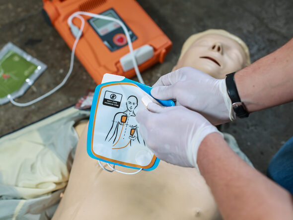 Training mit einem automatischen Defibrillator an einer Puppe