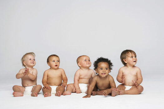 Row,Of,Multiethnic,Babies,Sitting,Side,By,Side,Looking,Away