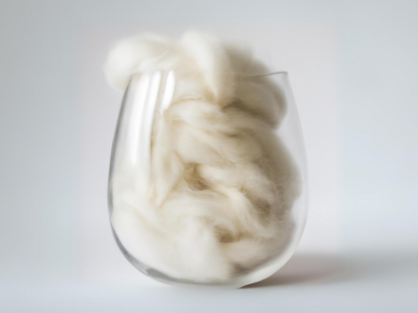 Ein Glas gefüllt mit Wollefasern