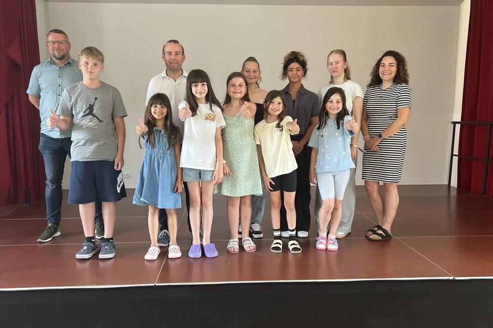 Die Beteiligten der "Sprachkurse von Schülern für Schüler": hinten v.l.: Stefan Bauroth (Stabsstelle Demografie, Bildung und Familie), Dirk Pfeufer (Schulleiter Luther-Grundschule), Neele Wendler, Alicia Gibson, Juliana Haischberger (alle Ernestinum, es fehlt Jasmin Gartner), Luisa Weber (Jugendsozialarbeit an Schulen) vorne: Schüler*innen der Lutherschule