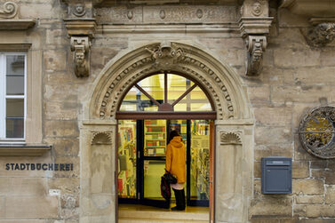 Eingang der Stadtbücherei mit Person.