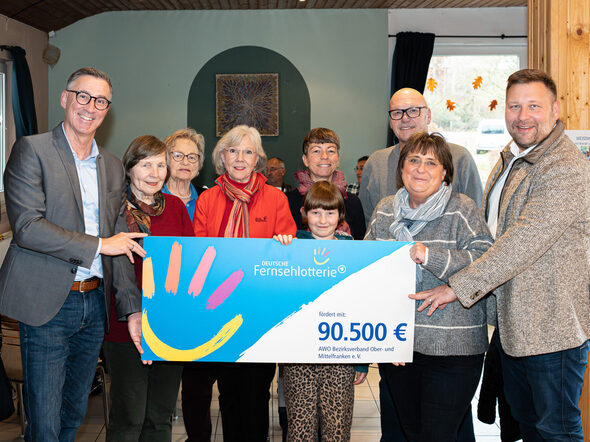 v.l.n.r.: 1. v. l. Holger Diez, Amtsleiter des Sozial- und Versicherungsamtes der Stadt Coburg; 2. Reihe, 5. v. l. Liane Blietzsch, Einrichtungsleiterin des Mehrgenerationenhauses des AWO Bezirksverband Ober- und Mittelfranken e.V.; 1. Reihe, 6 v. l. Birgit Schober, Verwaltungsleiterin Mehrgenerationenhauses der AWO & 1. v. r. Stephan Masch, Repräsentant der Deutschen Fernsehlotterie bei der symbolischen Übergabe der Fördersumme in Coburg gemeinsam mit Nutzern des Quartiersmanagements