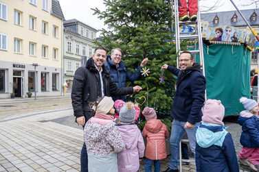 Can Aydin, Hubertus Prinz von Sachsen-Coburg und Gotha und Enrico Pizzato schmücken mit den Kindern aus dem Kinderhaus den Weihnachtsbaum.