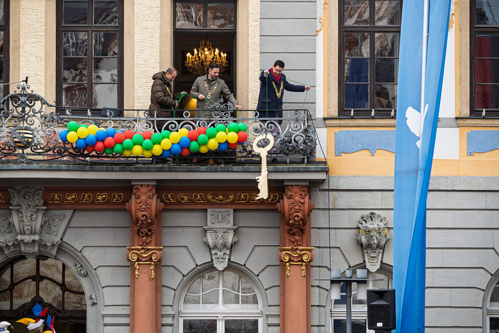 Rathaussturm 2025: Die drei Bürgermeister geben den Forderungen der Närrinen und Narrhalesen nach. Der Rathausschlüssel wird abgeseilt.