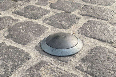 Unter diesen Deckeln stecken Sensoren, die erkennen, ob der Parkplatz besetzt ist.