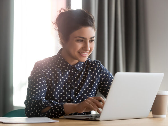 Eine junge Frau arbeitet an einem Laptop