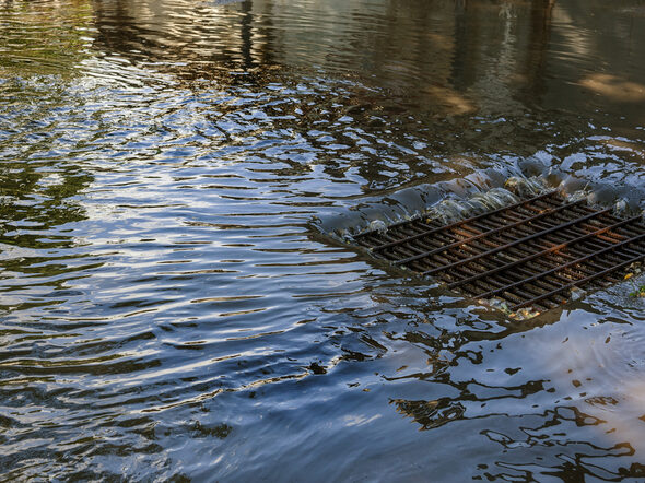 Regenwasser fließt in eine Abfluss bei starkem Regen