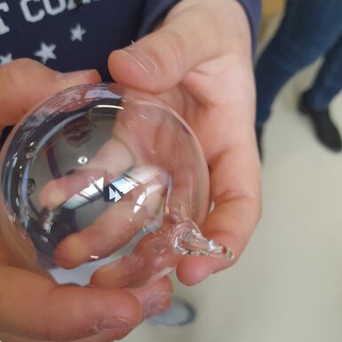 Nahaufnahme von einer Glaskugel in einer Kinderhand