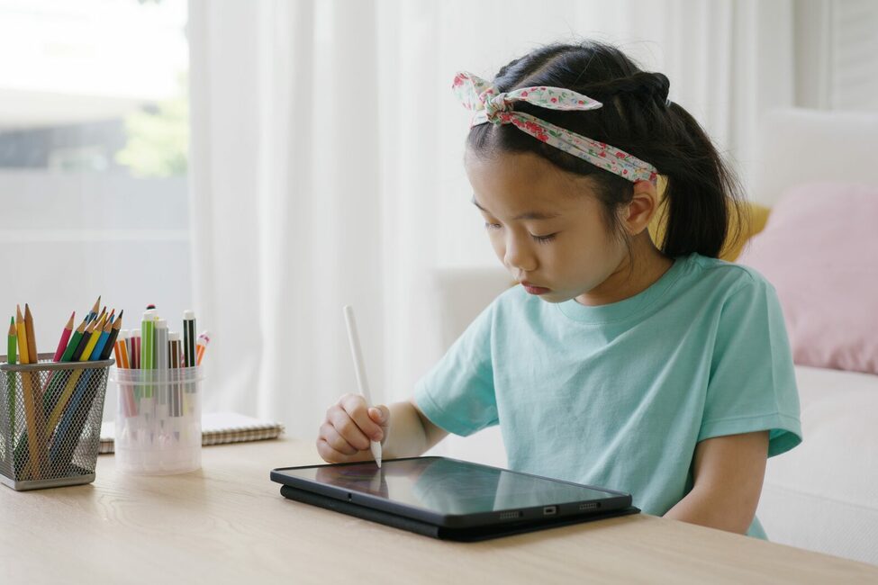 Mädchen malt etwas auf einem Tablet