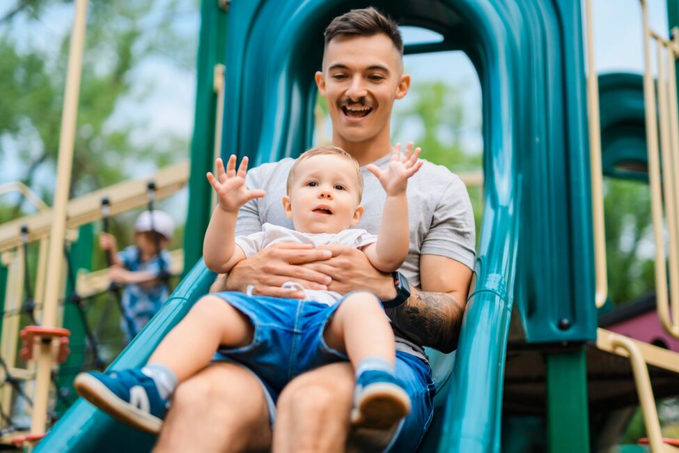 A,Father,With,Child,Boy,Is,Sitting,On,The,Slide