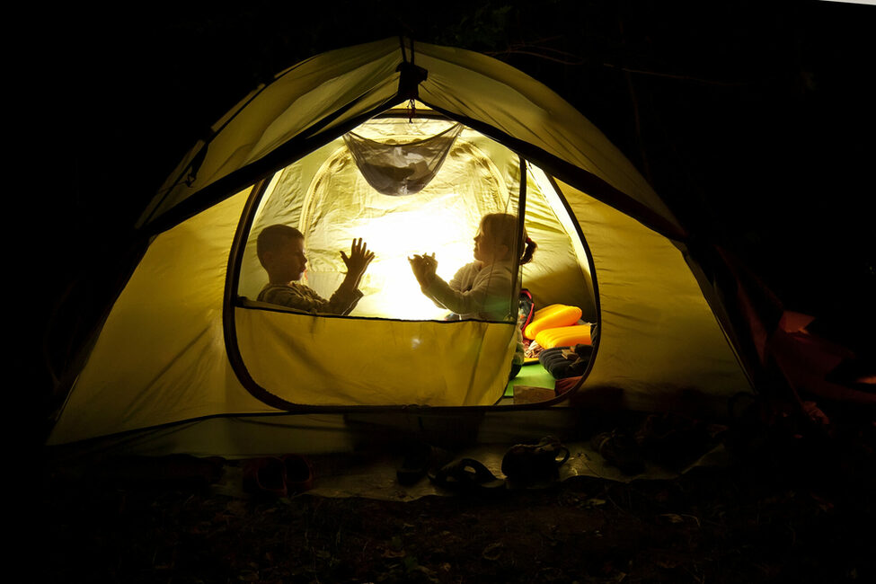 Kinder spielen nachts in einem Zelt