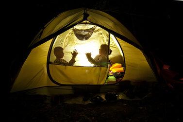Kinder spielen nachts in einem Zelt