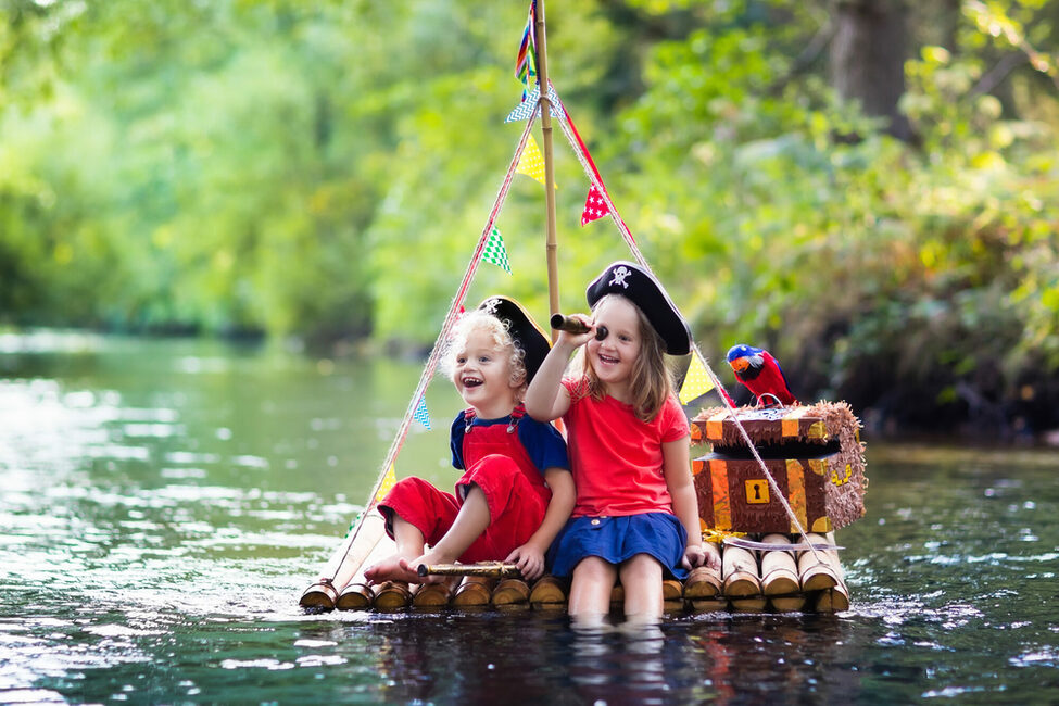Kinder auf einem Floß spielen Piraten