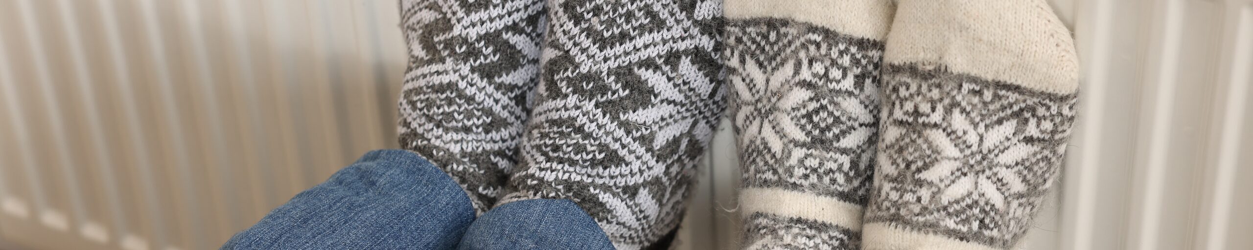 Couple,Warming,Feet,Near,Heating,Radiator,At,Home,,Closeup