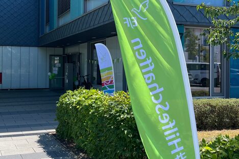 Außenansicht der Schule am Hofgarten mit Beachflag im Vordergrund