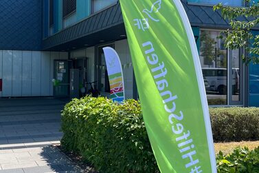 Außenansicht der Schule am Hofgarten mit Beachflag im Vordergrund