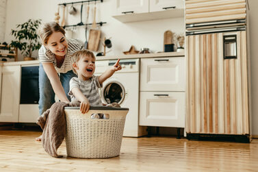 Mutter mit Kind im Wäschekorb