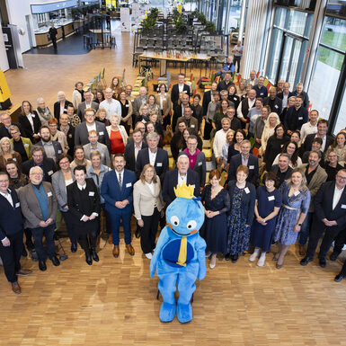 Gruppenbild aller Bündnispartner mit Maskottchen Büni im Vordergrund