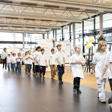Schülerinnen und Schüler laufen hintereinander.