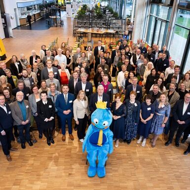 Gruppenbild aller Bündnispartner mit Maskottchen Büni im Vordergrund