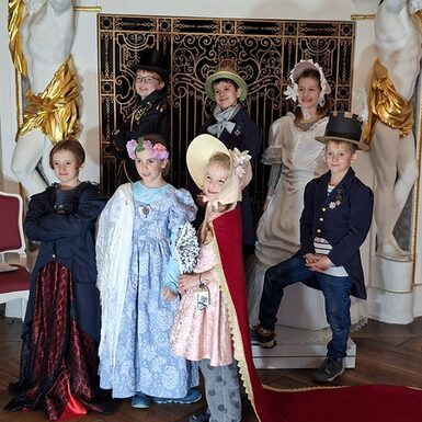 Kinder sind verkleidet wie früher und lächeln in die Kamera.