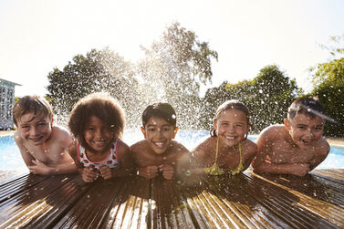 Kinder genießen den Sommer im Schwimmbad