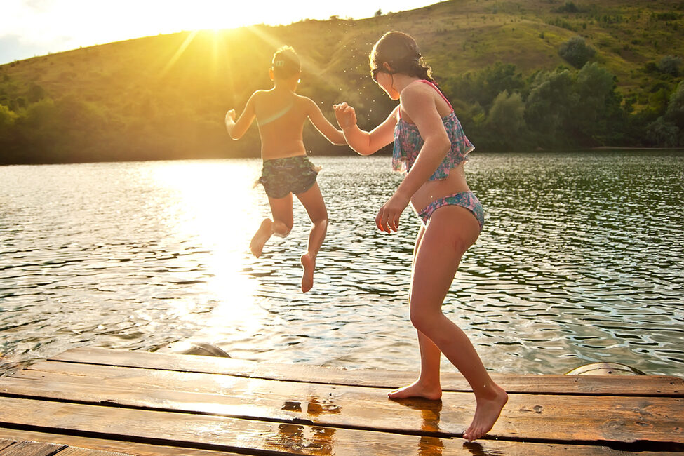 Kinder spielen an einem Waldsee